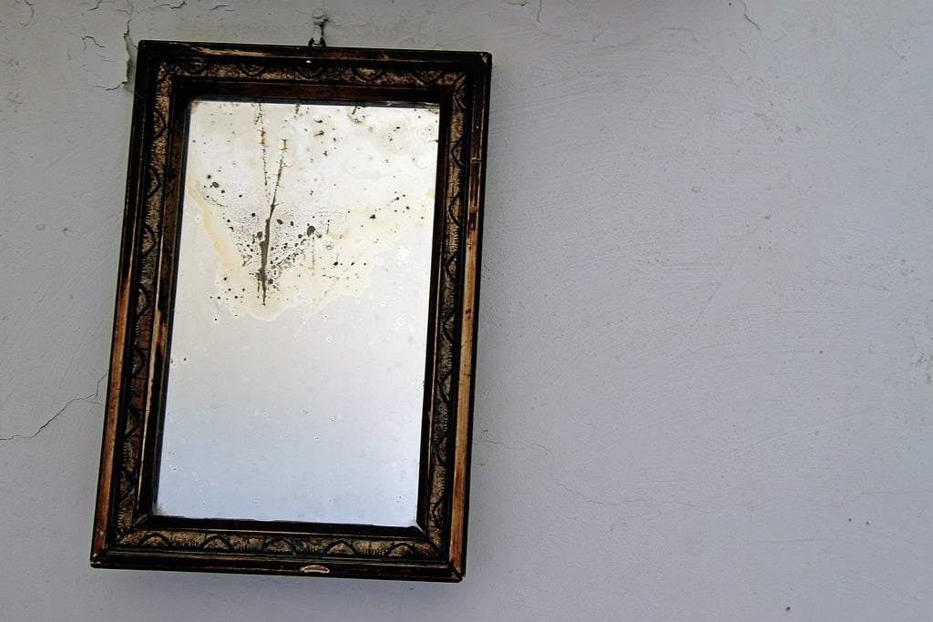 An old mirror hung on the wall
