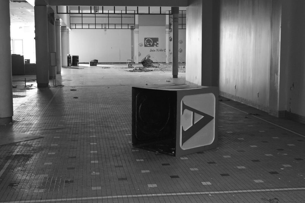 An oversized child's alphabet block inside a dead mall