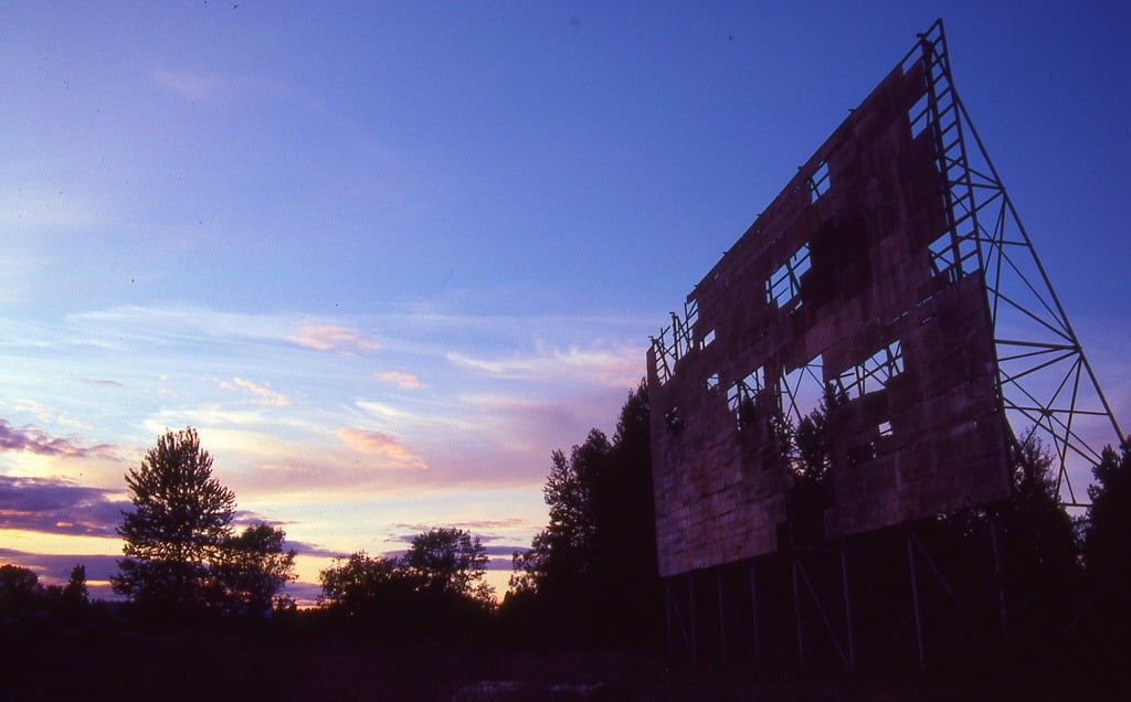A decaying drive-in movie screen at sunset