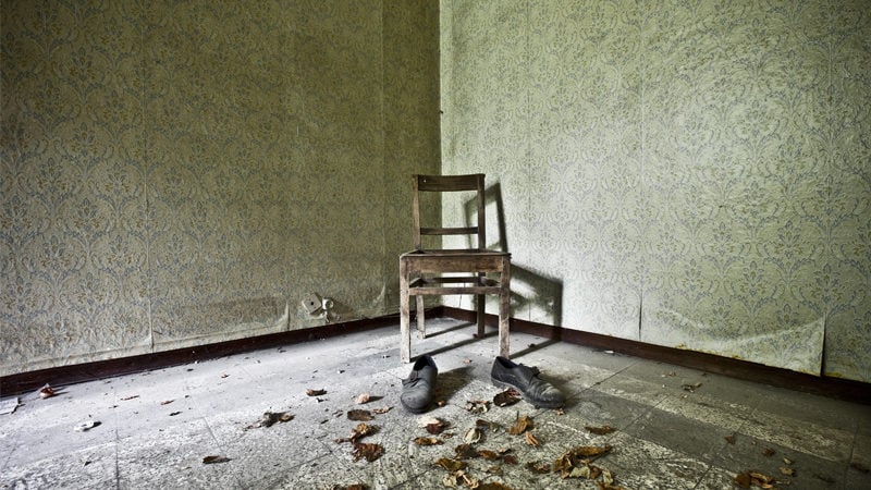 An abandoned chair in an empty room