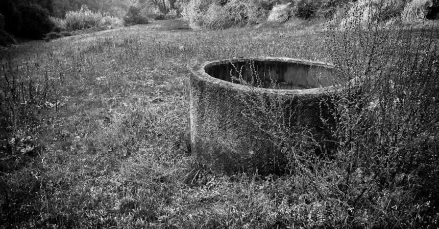 A stone well in a field