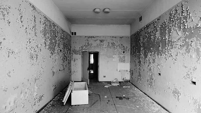 an empty room in an abandoned building with a single cardboard box on the floor