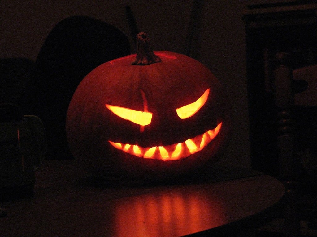 A lit jack o lantern in a dark room