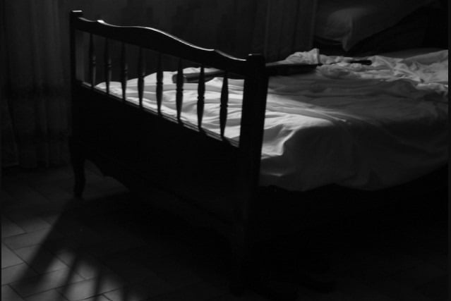 A bed in a darkened room