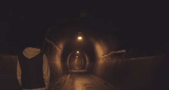 A person walking through Kiyotaki Tunnel at night