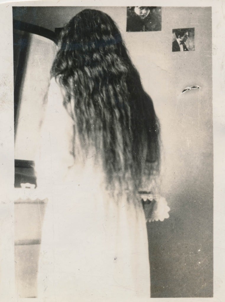 A woman in white with long, dark hair