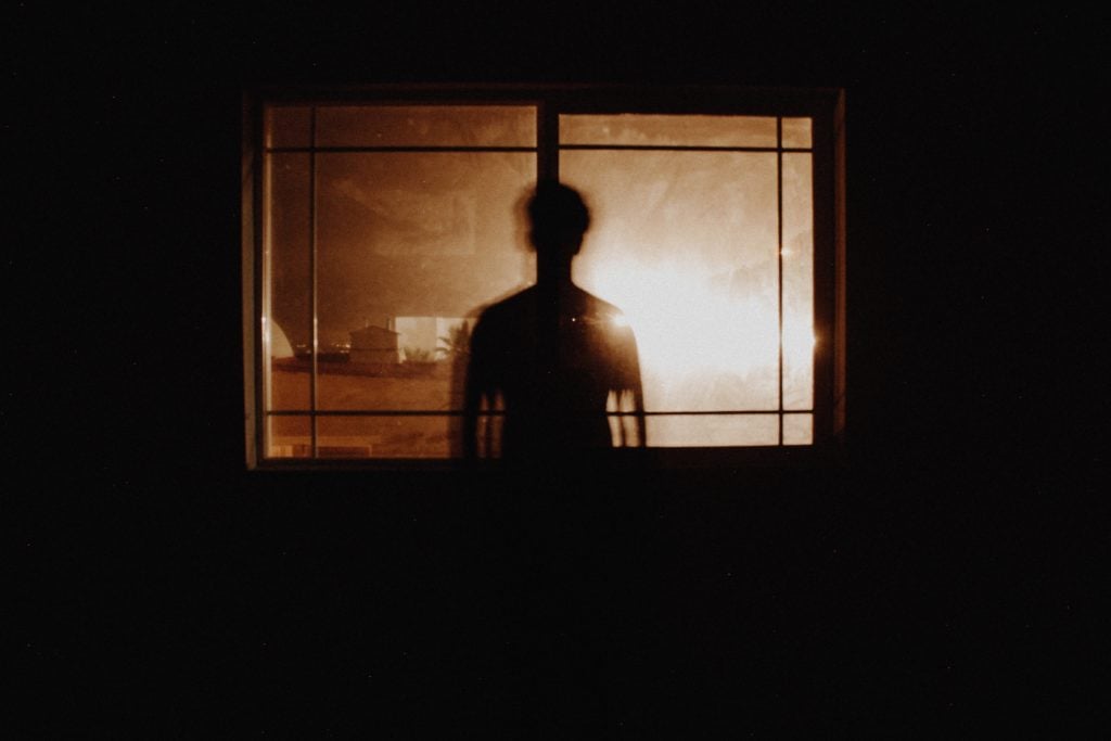 A figure silhouetted in the dark