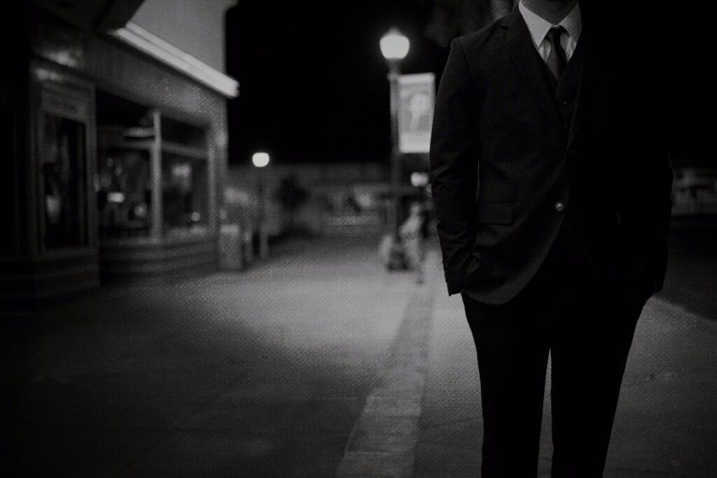 A man in a suit on a dark street