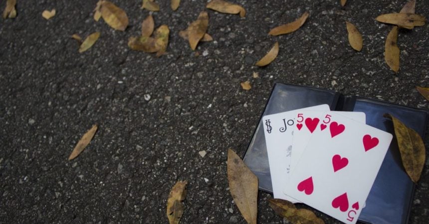 Playing cards on the ground with dry leaves