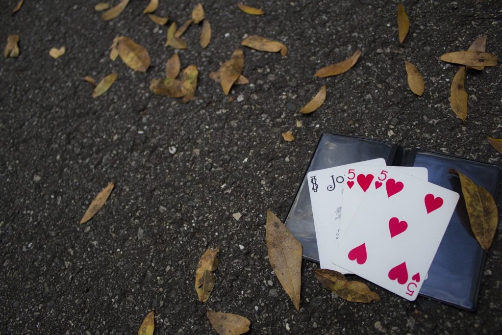Playing cards on the ground with dry leaves