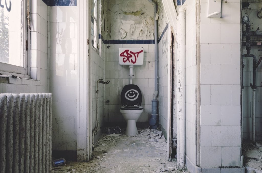A toilet in an abandoned bathroom