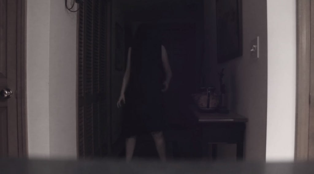 Screenshot from Hi I'm Mary Mary showing the woman in black standing in a dark hallway