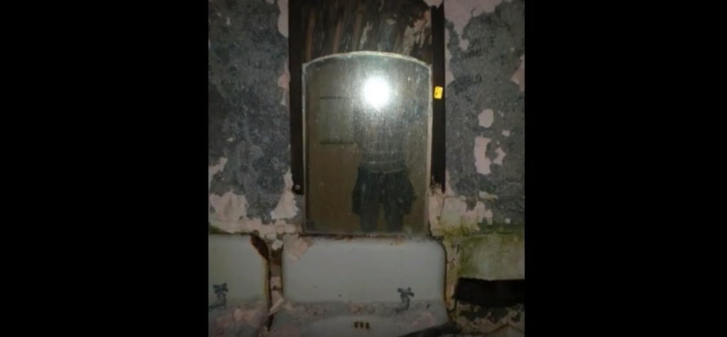 Someone taking a flash photograph in a mirror in the abandoned ruins of the Pennhurst State School and Hospital
