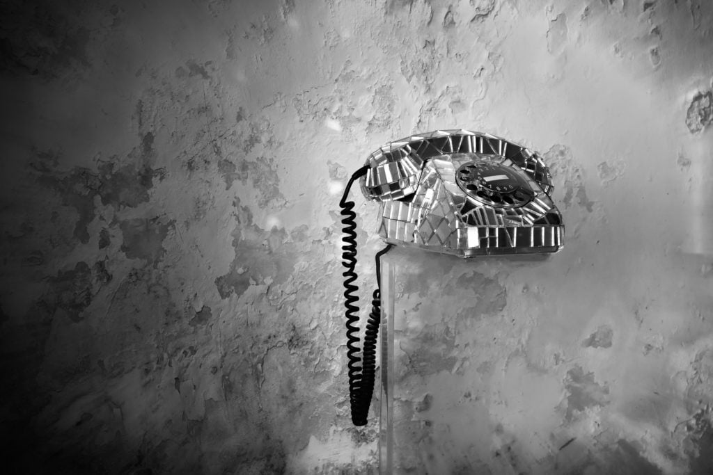 A rotary telephone covered in glass shards