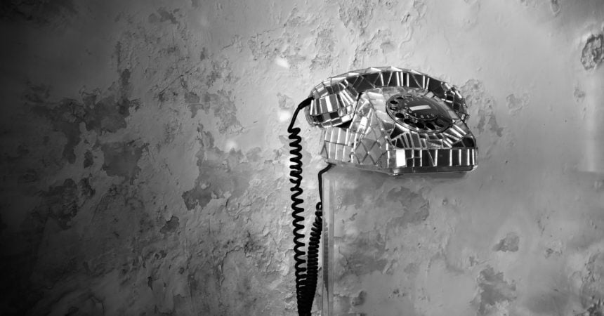 A rotary telephone covered in glass shards