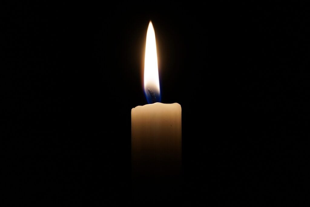A candle burning in a dark room