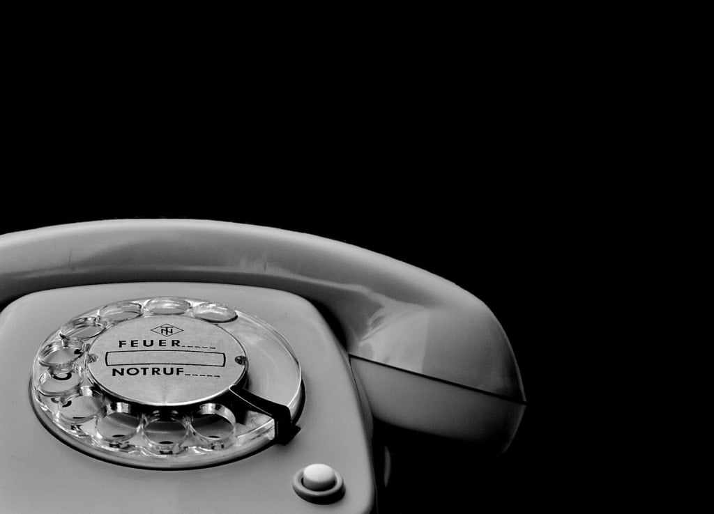 A black and white photograph of an old rotary telephone