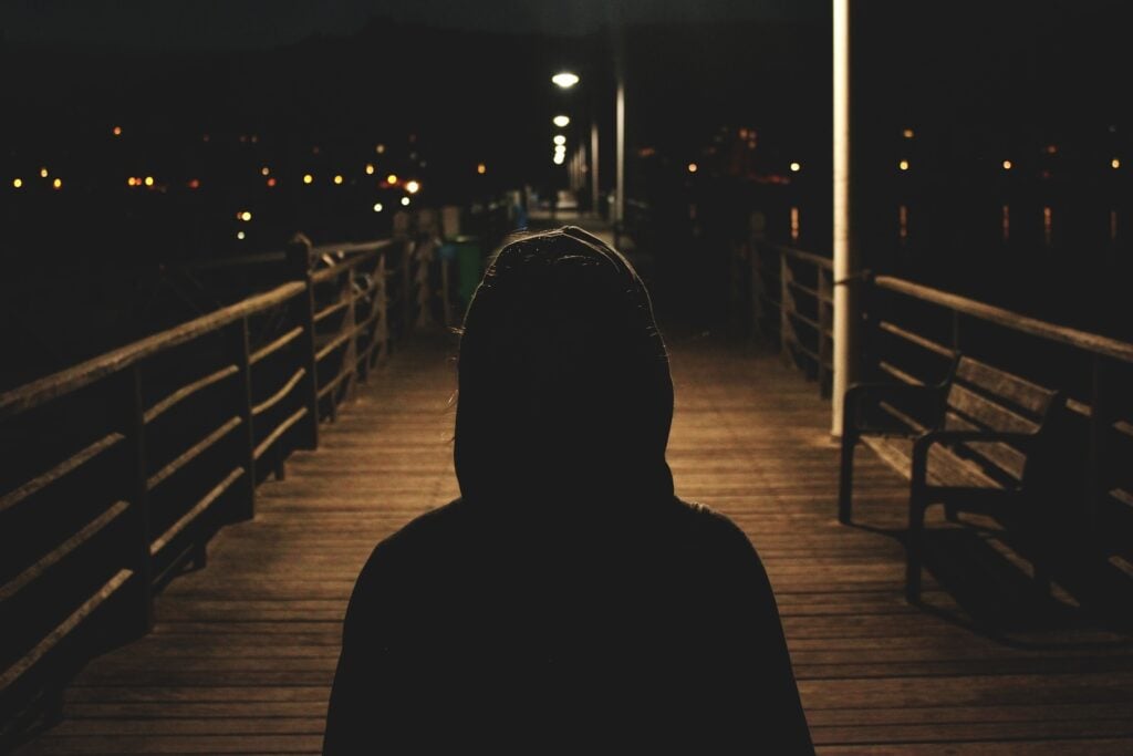 A person wearing a hoodie at night