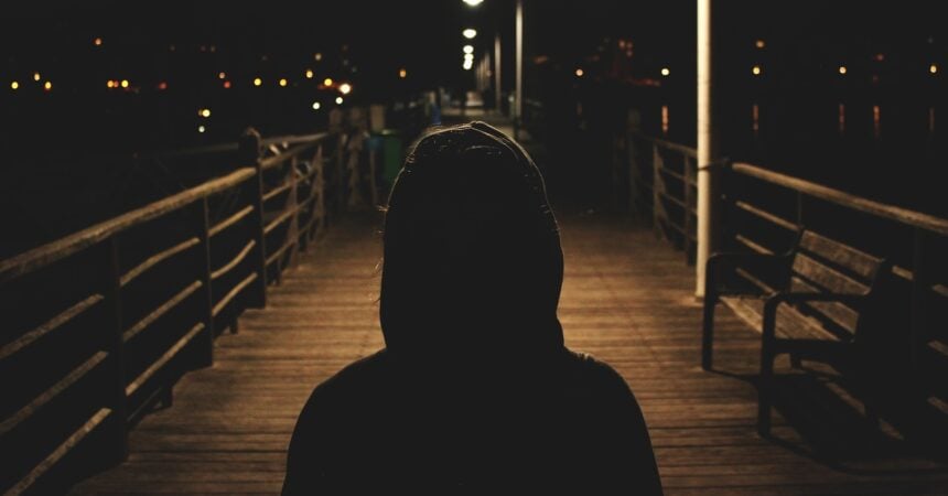 A person wearing a hoodie at night