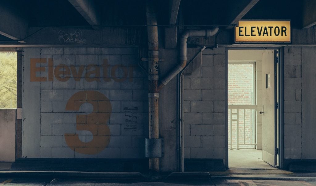 A door labeled "elevator" in a parking garage