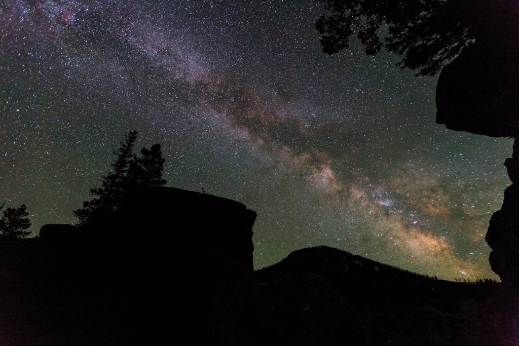 The Milky Way in the night sky over a cliff