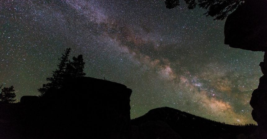 The Milky Way in the night sky over a cliff