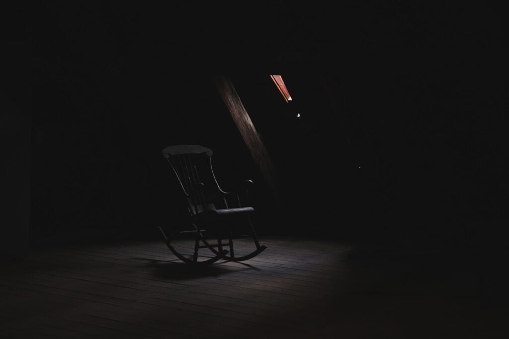 A rocking chair in a dark room