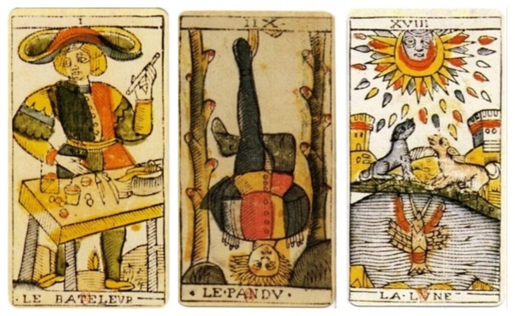 Three cards from the Tarot de Marseille deck: From left to right, the Magician, the Hanged Man, and the Moon.