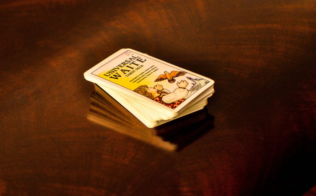 The Universal Waite tarot deck, cards sitting stacked on a wooden surface.