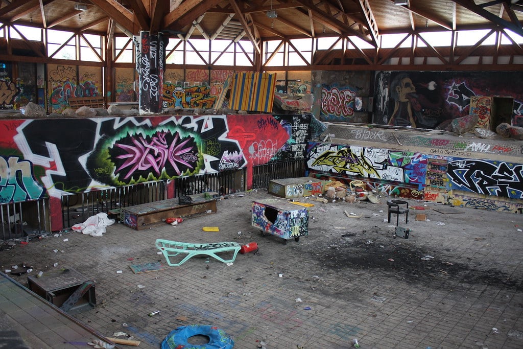 A long, wide shot of the indoor pool at the abandoned Blub water park in Berlin, 2014. Everything is covered in graffiti.