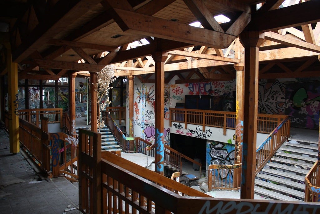 Open balconies and stairs made from wooden post-and-beam construction at the abandoned Blub water park in Berlin, 2015. There is lots of graffiti everywhere.