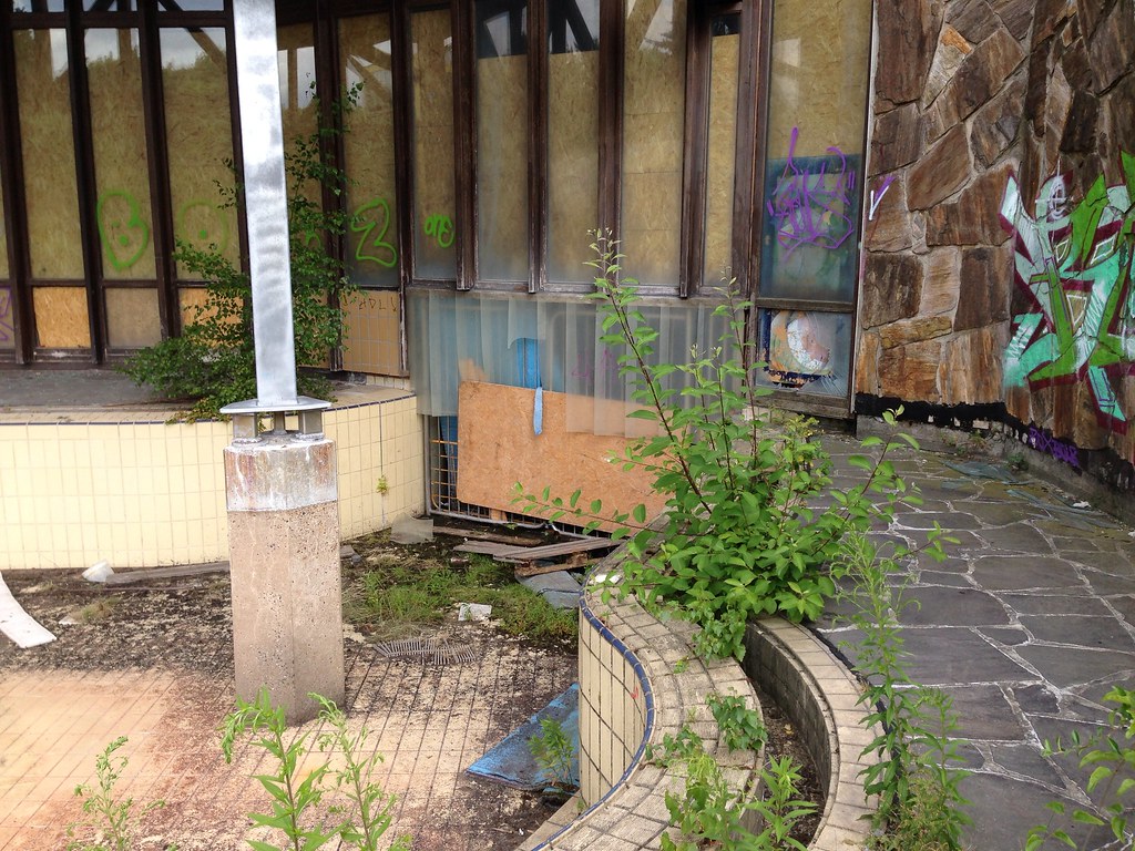An empty, overgrown, outdoor pool at the abandoned Blub water park in Berlin, 2013.