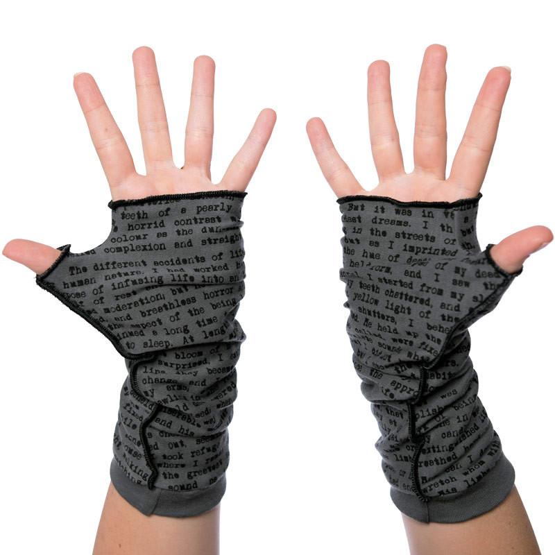 Grey fingerless gloves on a pair of hands. The glove have the text of Frankenstein written on them in black.