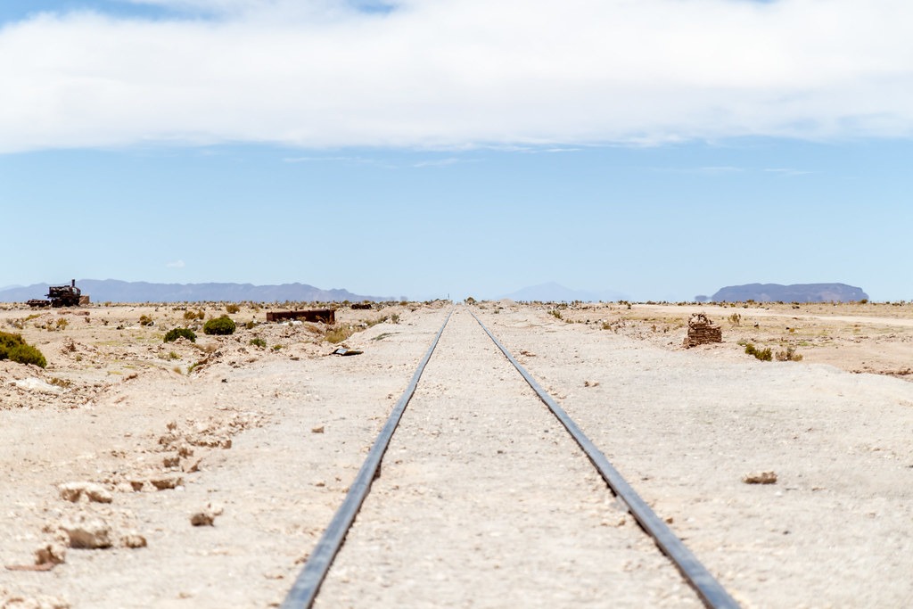 Abandoned train tracks in the desert, stretching out into the horizon and going nowhere.