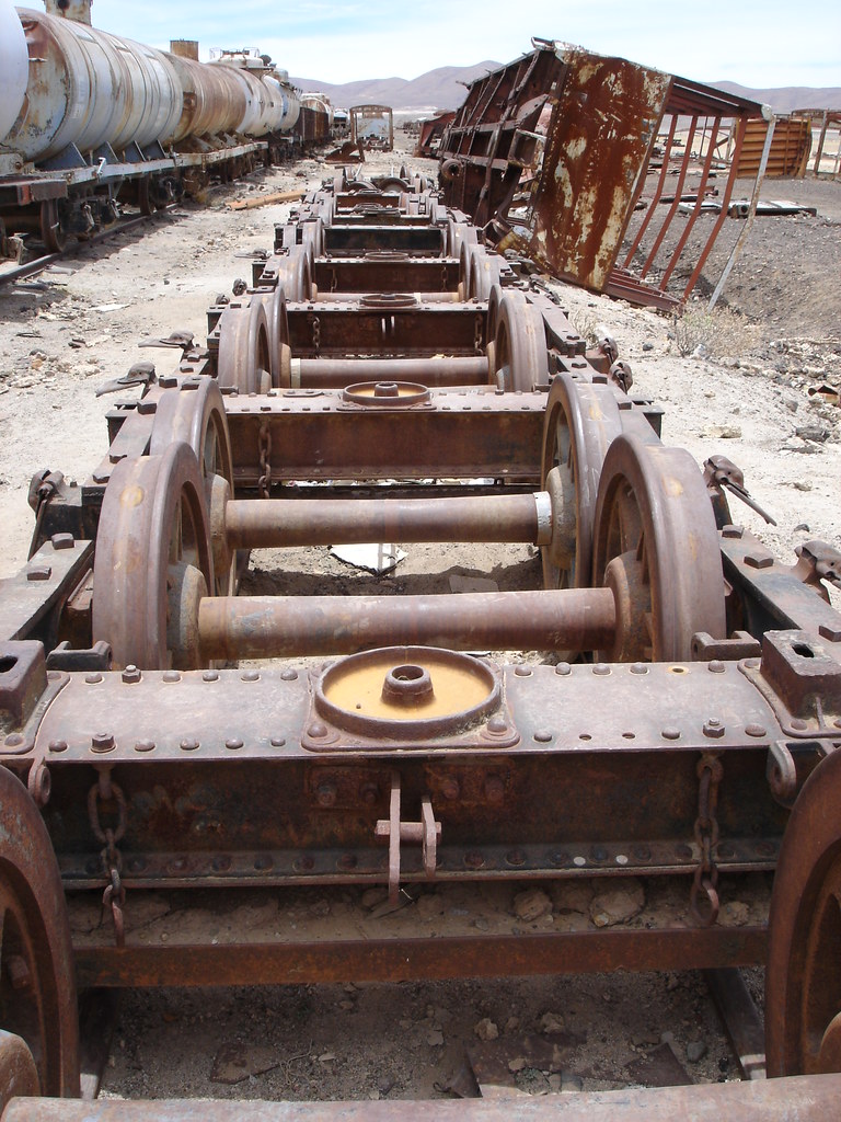 A row of train wheels without a car, abandoned in the desert.