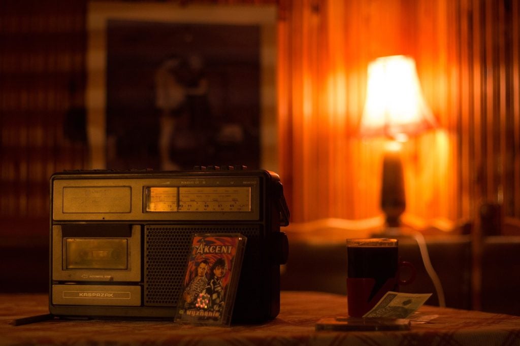 A vintage cassette player/radio in a dimly-lit room