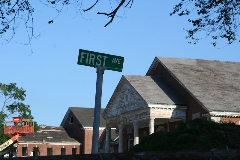 A green street sign for First Ave at Fairfield Hills