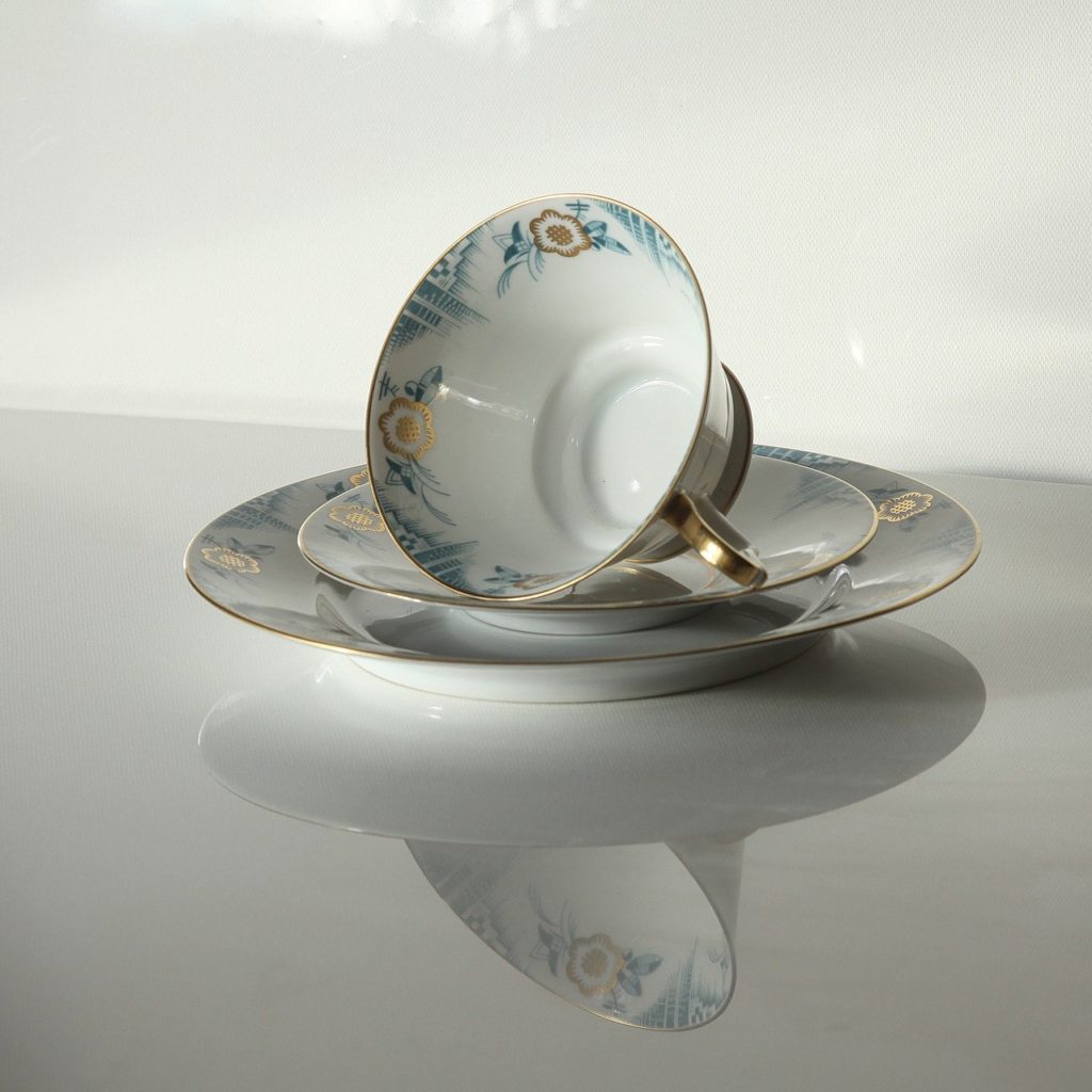An empty tea cup turned on its side, sitting in a saucer