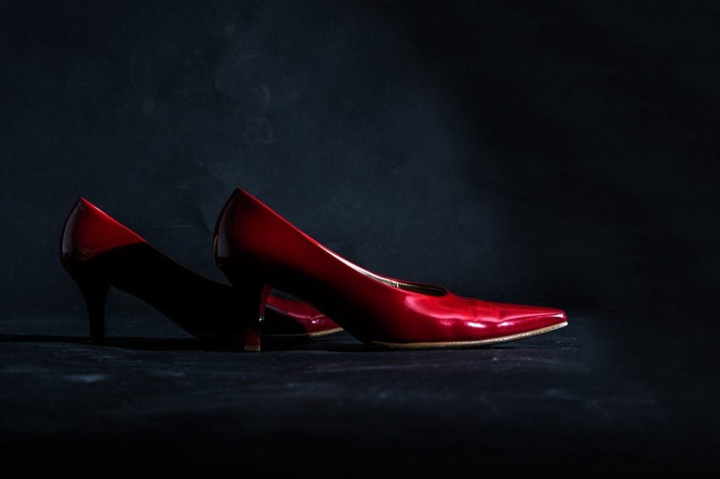 A pair of red high heel shoes in a dark environment