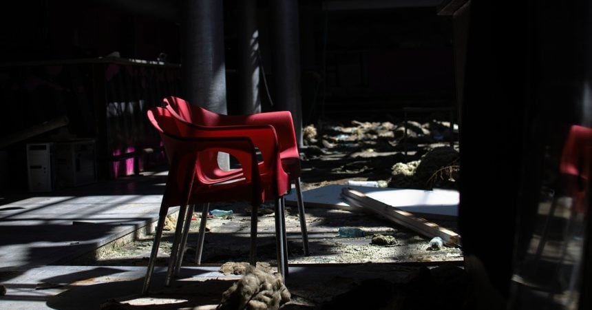 A red chair in a decaying, abandoned room