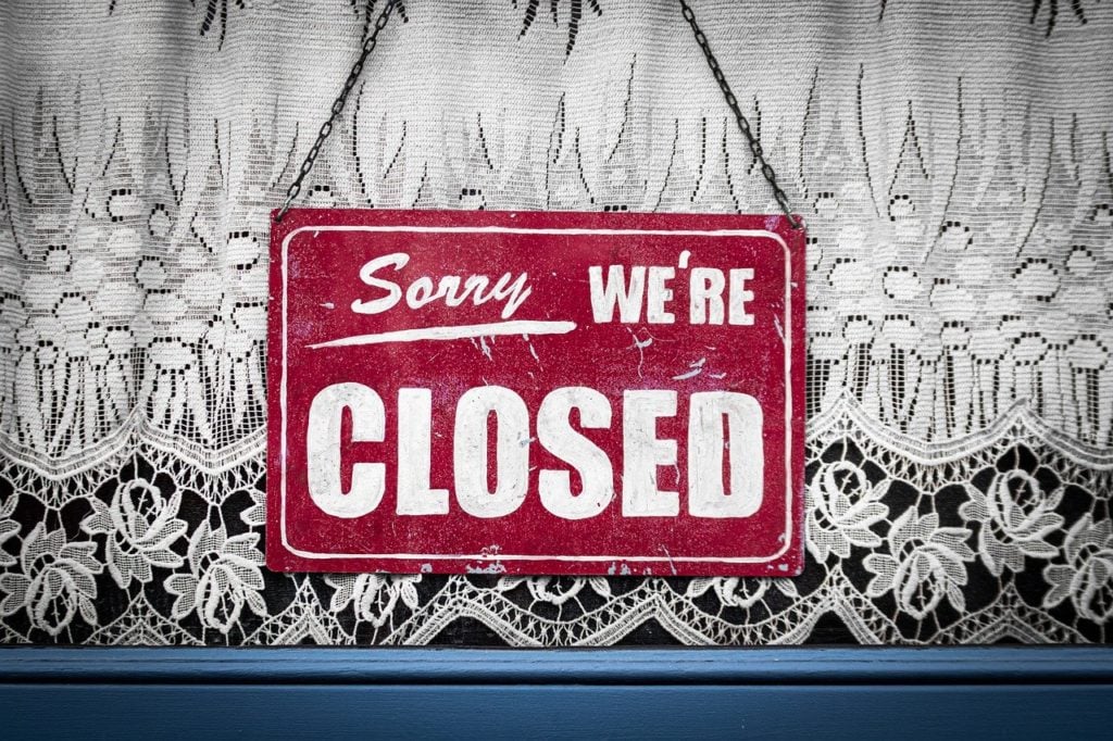 "Sorry, We're Closed" sign hung in a window