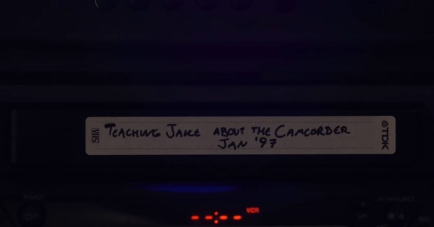 A VHS tape labeled "Teaching Jake About The Camcorder, Jan. '97" sticking out of a VCR