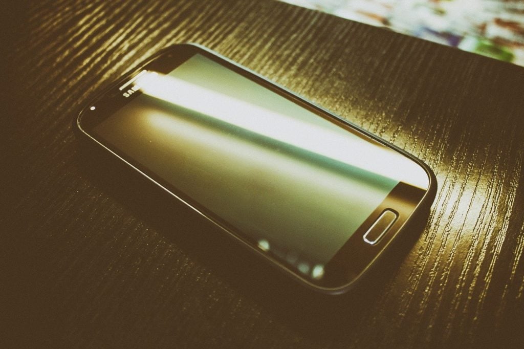 A smartphone sitting on a wooden tabletop