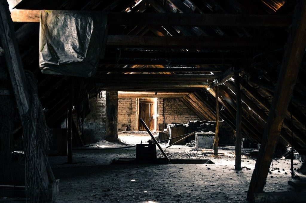 An old attic of primarily wood construction in an advanced state of decay