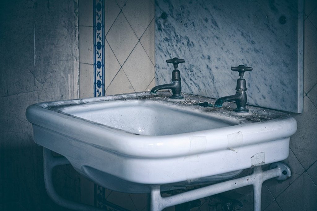An old bathroom sink with two faucets
