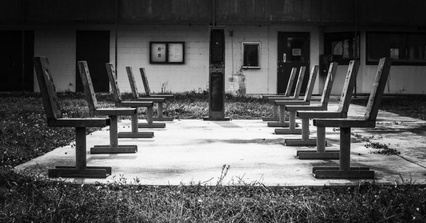 Two rows of empty chairs, facing each other in an abandoned playground