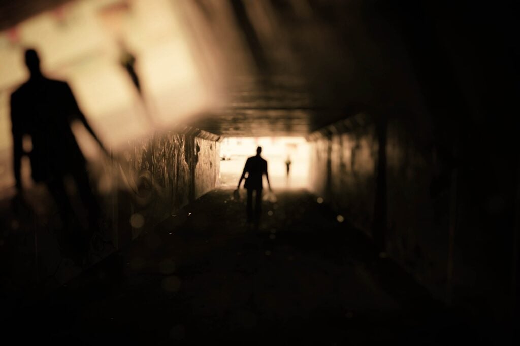 A human shadow at the end of a long, dark tunnel