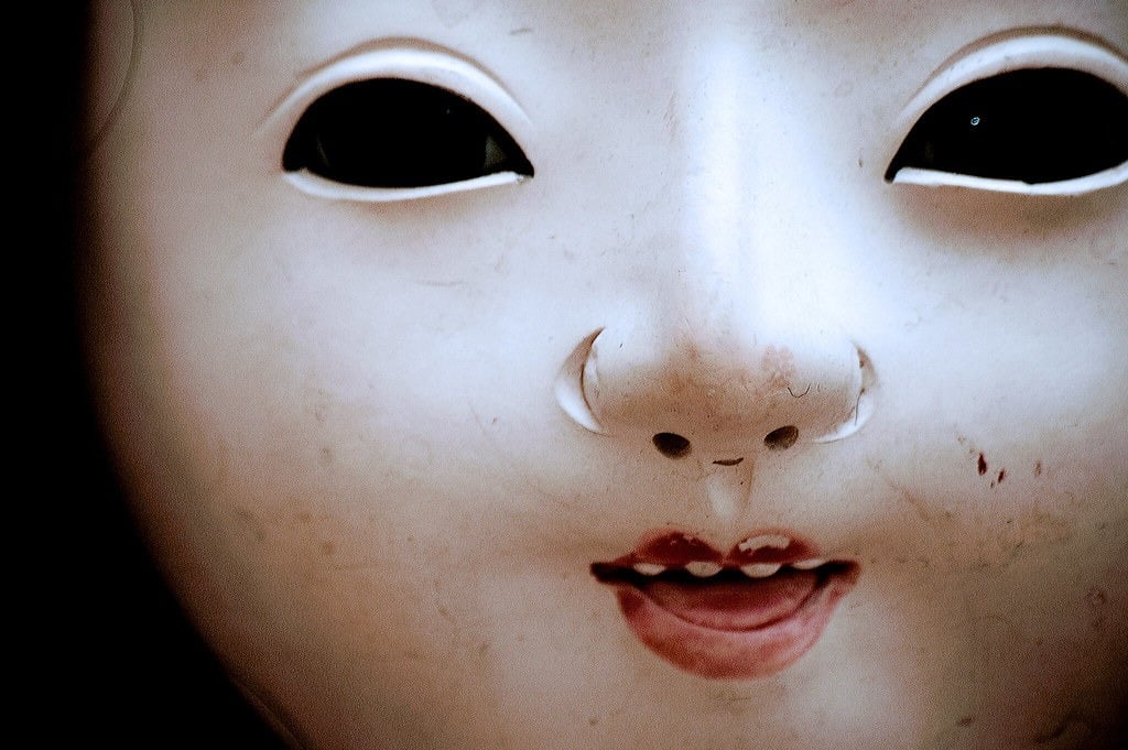 A close-up shot of a traditional Japanese doll's face