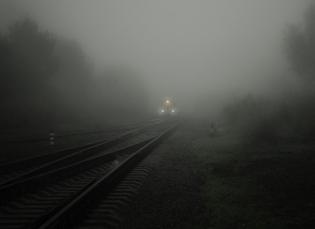 A train with headlights traveling through fog