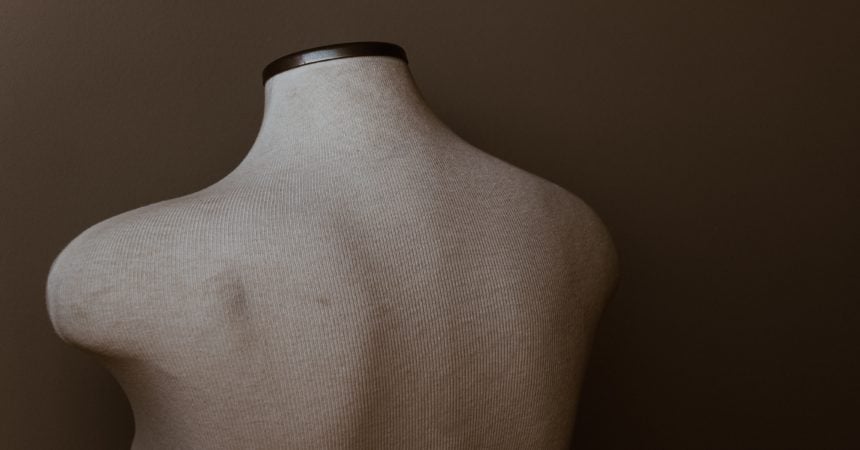 The torso of a dress maker's mannequin, viewed from the back